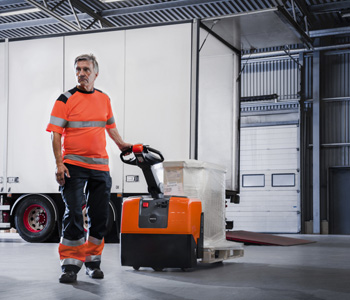 Chariot transpalette électrique Toyota à conducteur accompagnant lors du déchargement d’un camion